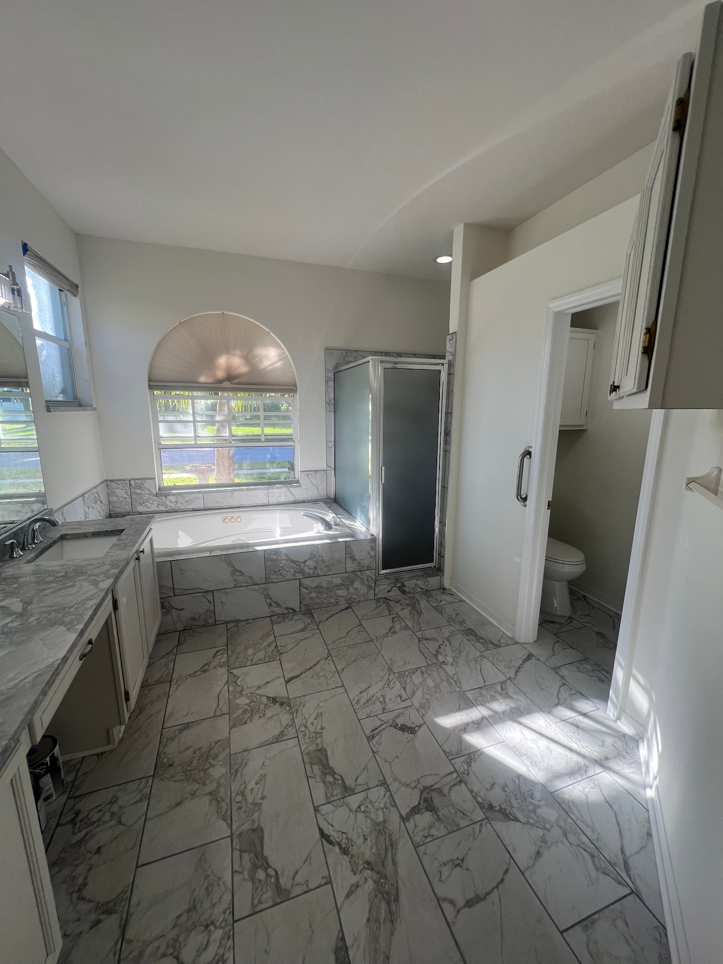 Completed bathroom renovation with natural stone tile and new vanity